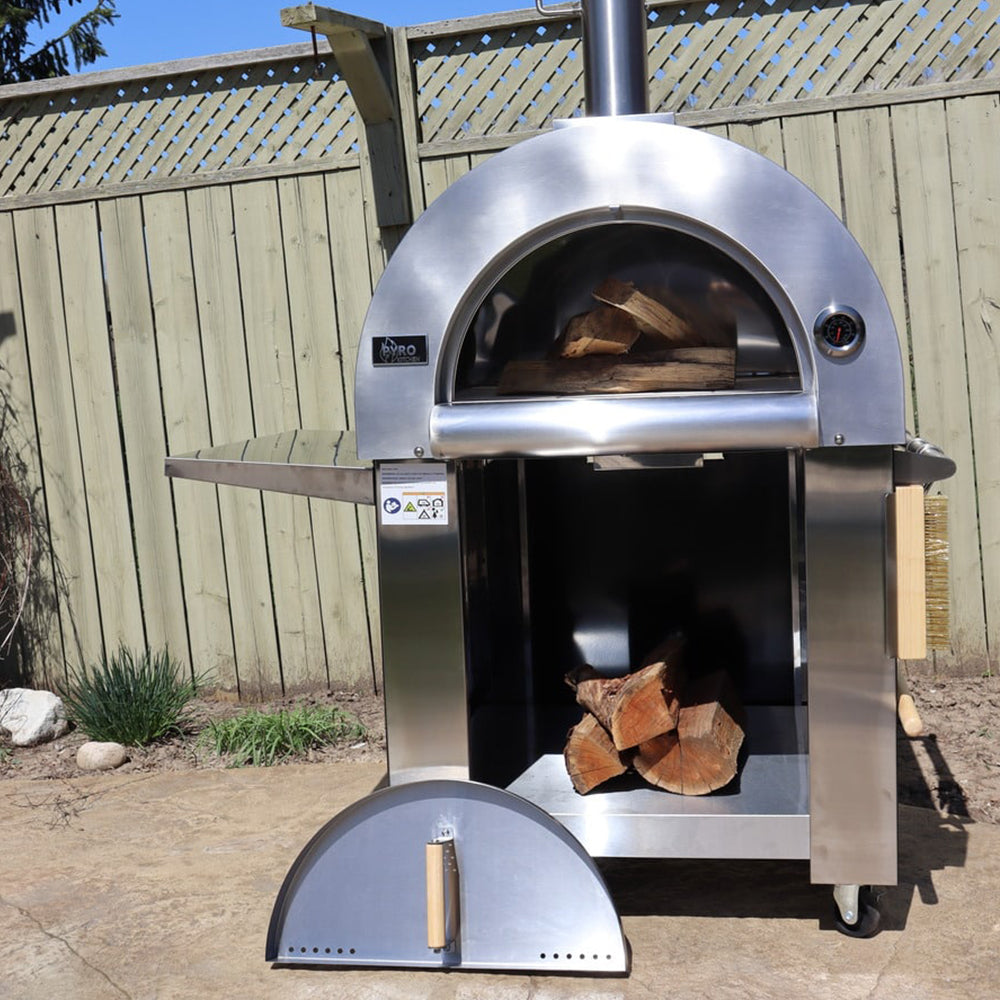 Front view of the Pyro Kitchen Vera V2 Wood Fired Pizza Oven with door open, showing logs stored under the oven in the spacious storage area.