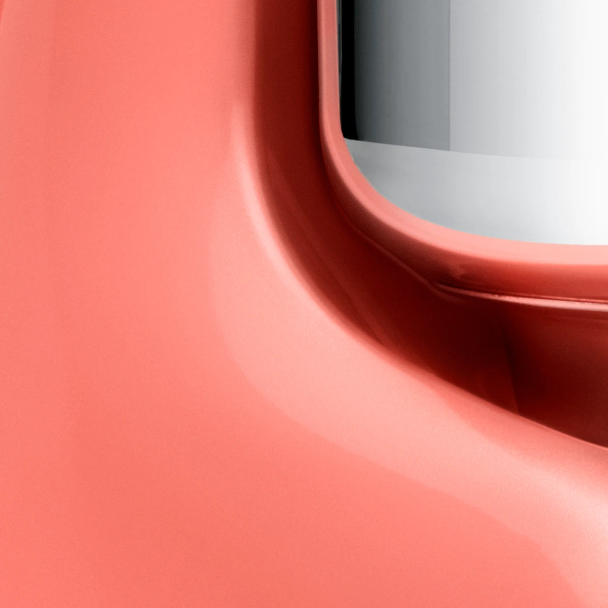 Close-up view of the Ankarsrum Assistent Original Stand Mixer in coral-crush (akm-6230-cc, gloss-finish), highlighting its premium build, powerful motor, and unique mixing bowl design for efficient dough kneading.