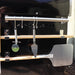 Close-up view of all accessories included with the Pyro Kitchen Caldo V2 Hybrid Pizza Oven, featuring a fold-up peel, Chicago-style cutter, brush, thick cordierite pizza stones, and log holder.