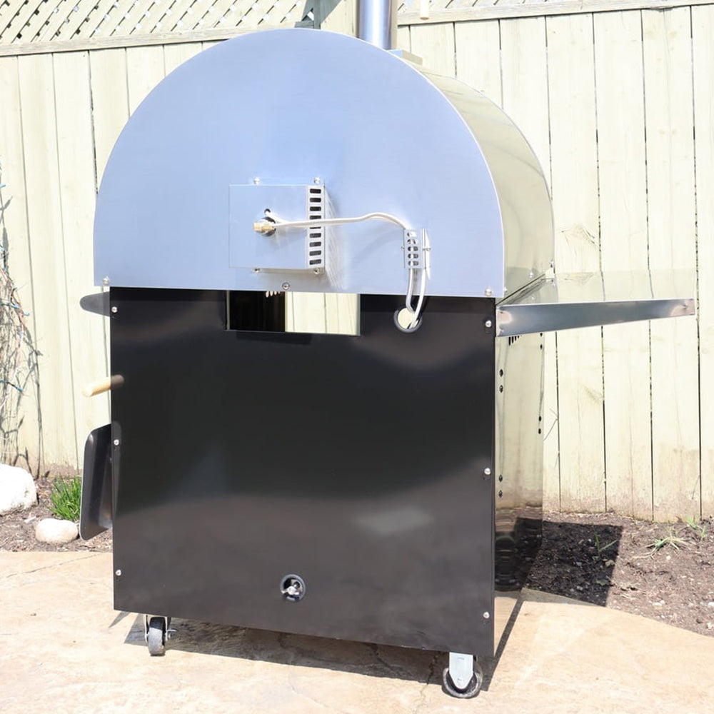 Back view of the Pyro Kitchen Caldo V2 Hybrid Pizza Oven with drip tray, gas connection, and stainless steel burner cover for durability when using wood.