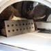 Interior view of the Pyro Kitchen Caldo V2 Hybrid Pizza Oven with log holder and thick cordierite pizza stones for perfect heat retention and distribution.