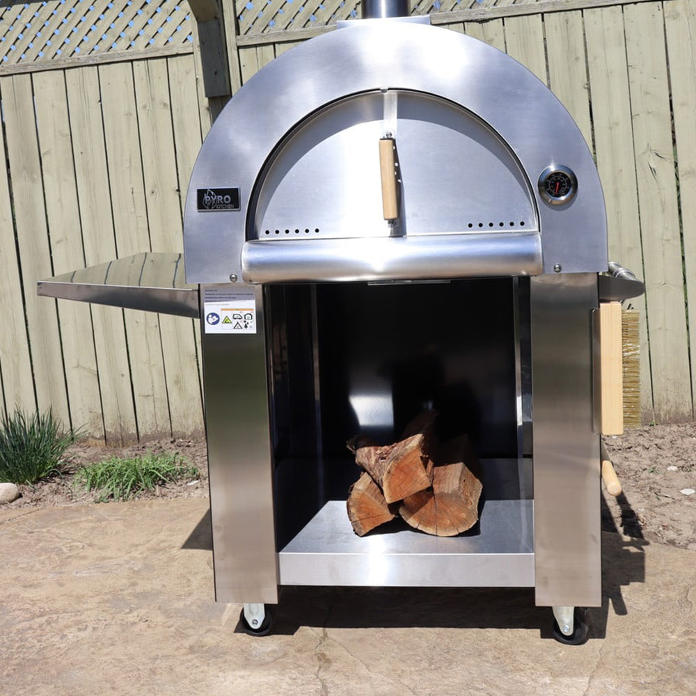 Front view of the Pyro Kitchen Vera V2 Wood Fired Pizza Oven with door closed and logs stored in the protected storage area beneath the oven.